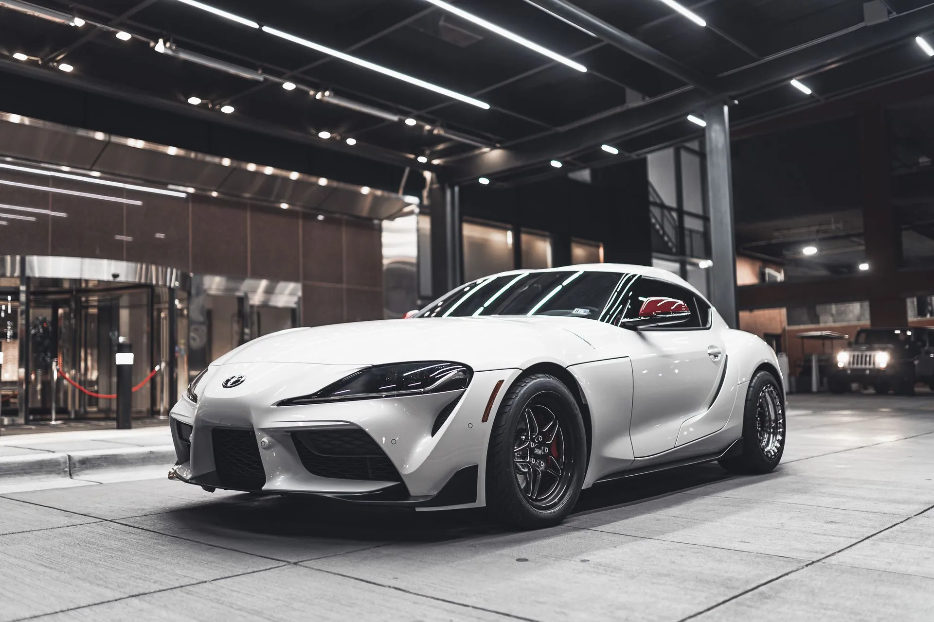 White sports car in a night garage, ready for transport